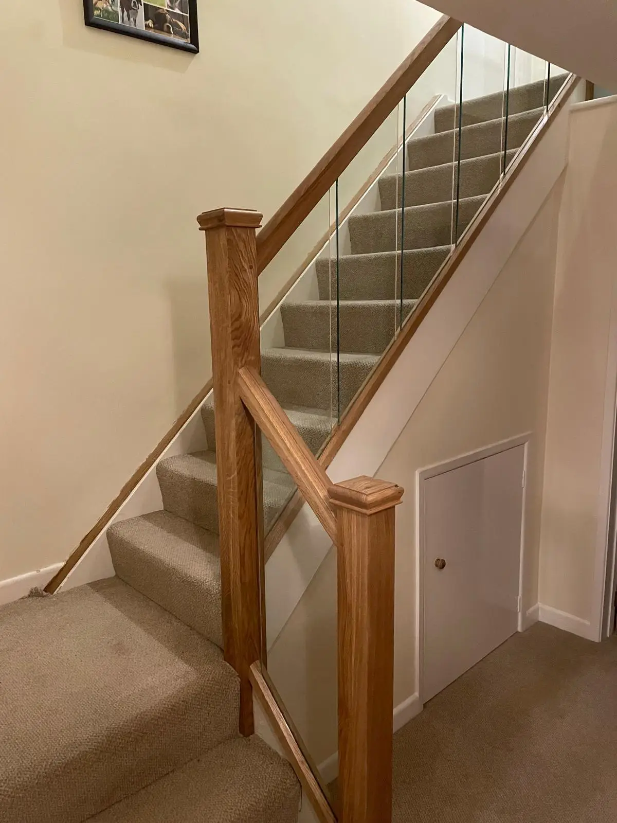 Oak staircase with glass balustrade panels in a finished hallway