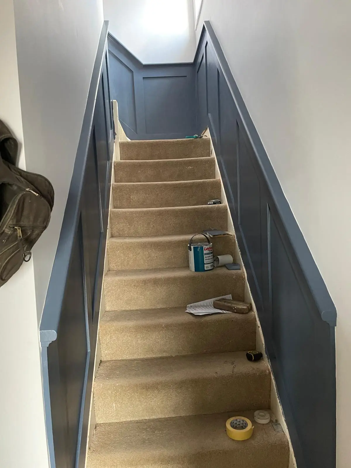 Straight staircase with blue-grey panelled walls running the full length of the flight
