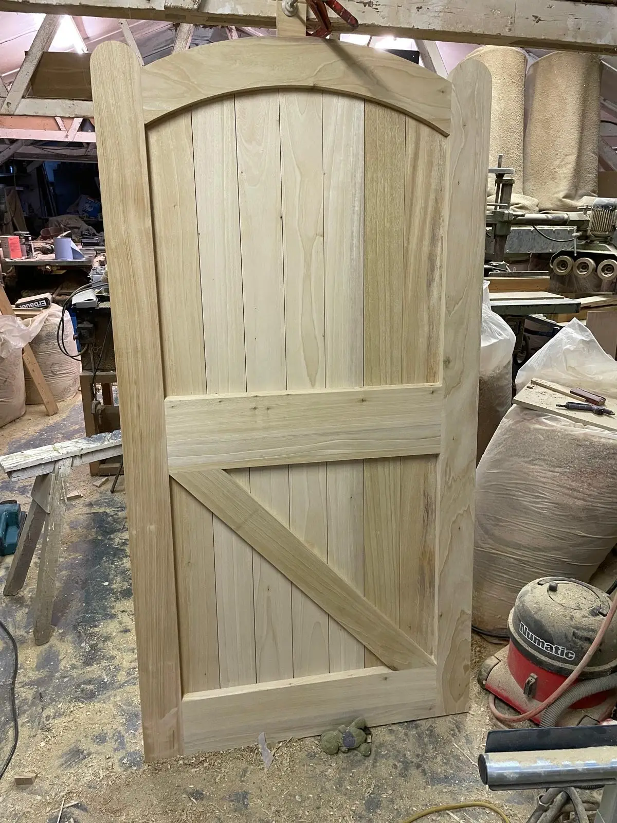 Bespoke arched-top timber garden gate with vertical boards and diagonal brace, freshly made
